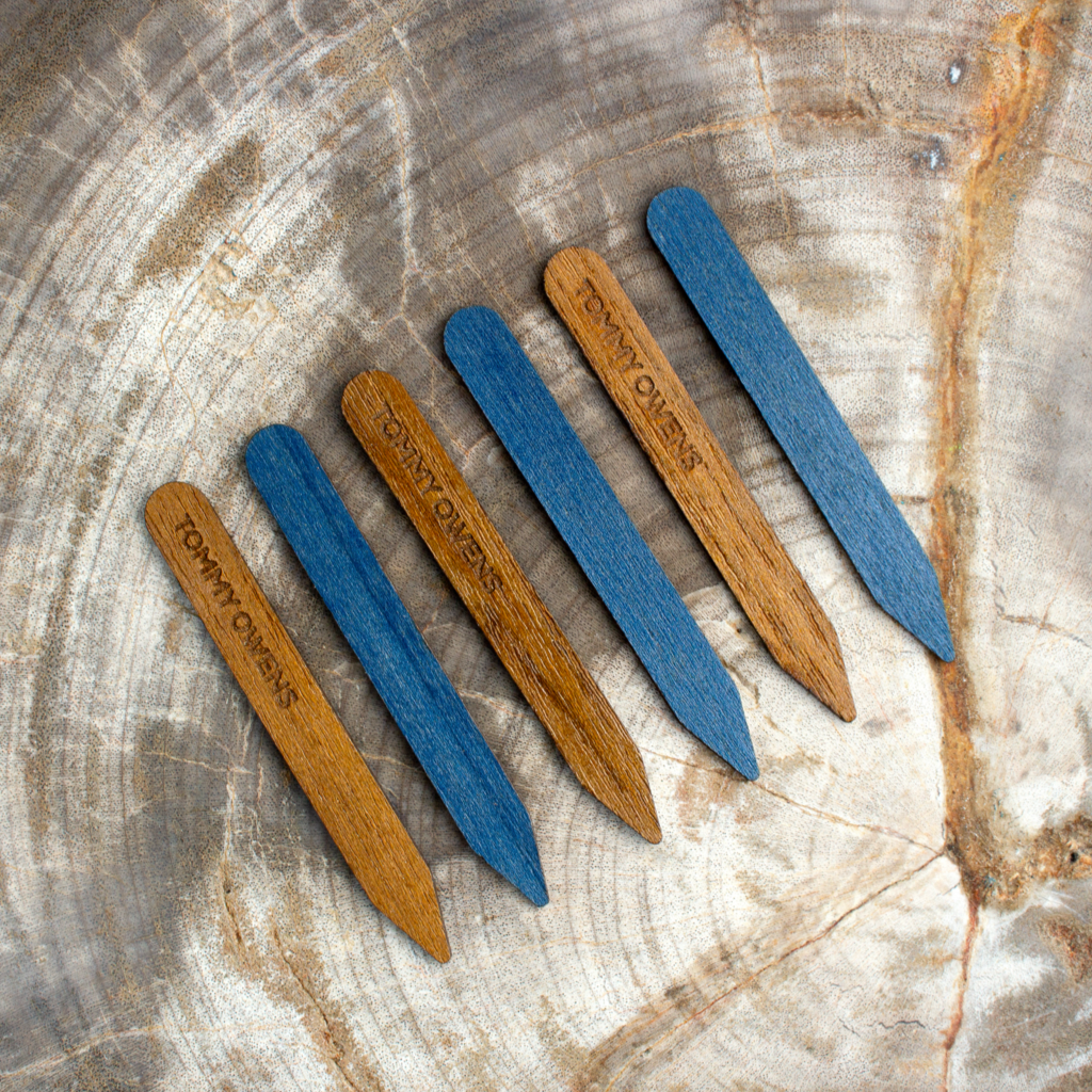 Two-tone teak and blue maple collar stays arranged side-by-side, showcasing the contrasting colors and natural beauty.
