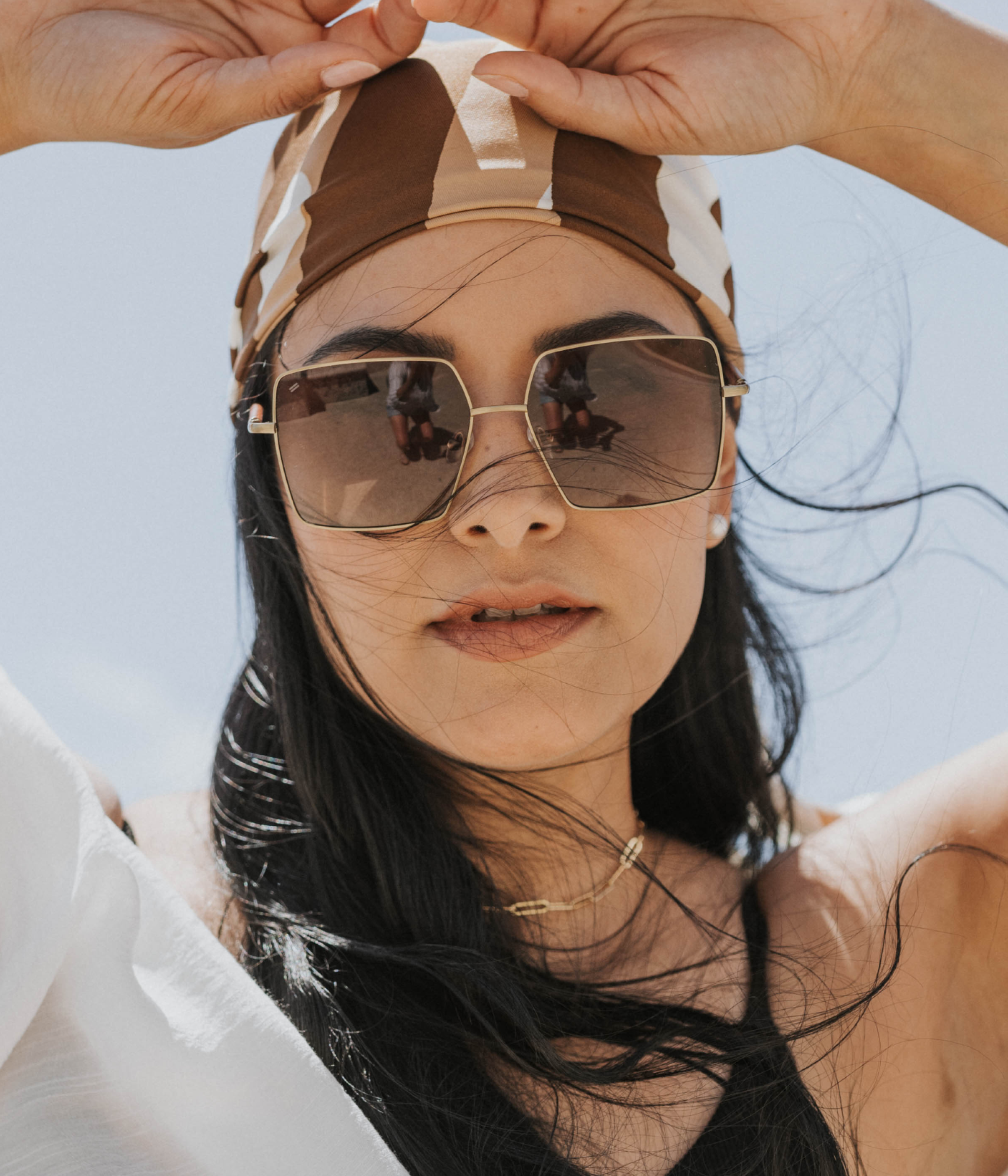 Lucie sunglasses with walnut wood and metal worn on the beach near Worth Avenue in Palm Beach