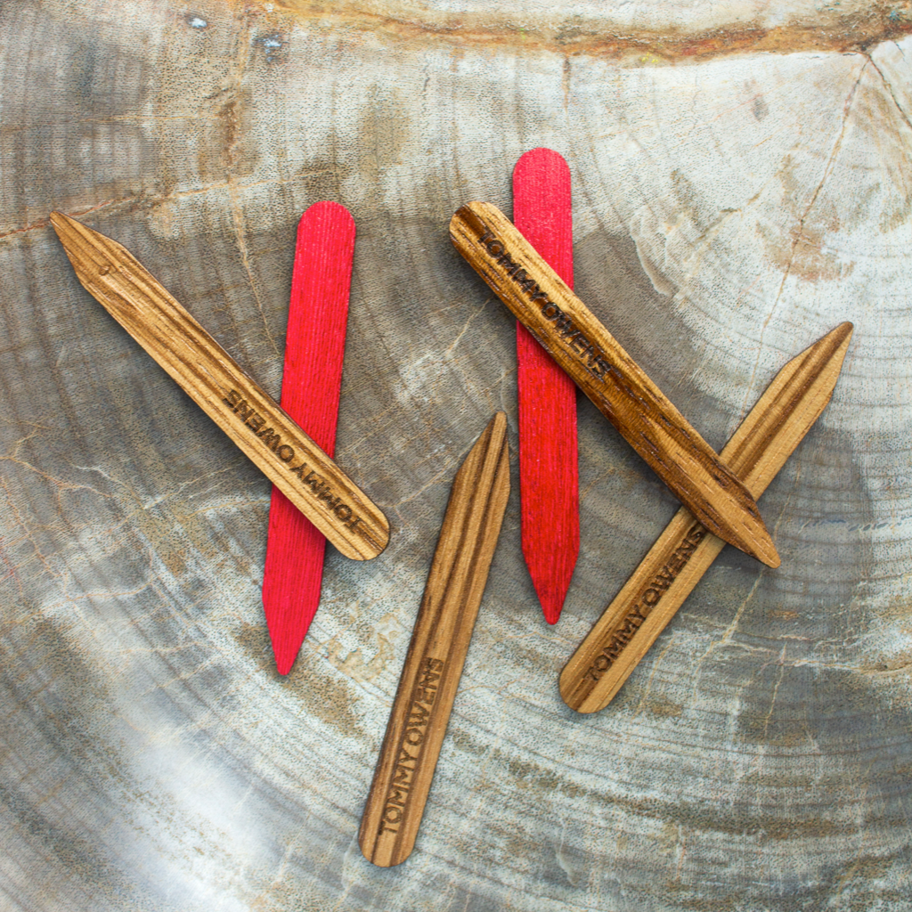 Zebrawood and red koto collar stays scattered amongst colorful beads and fabrics, emphasizing their exotic appeal and versatility.