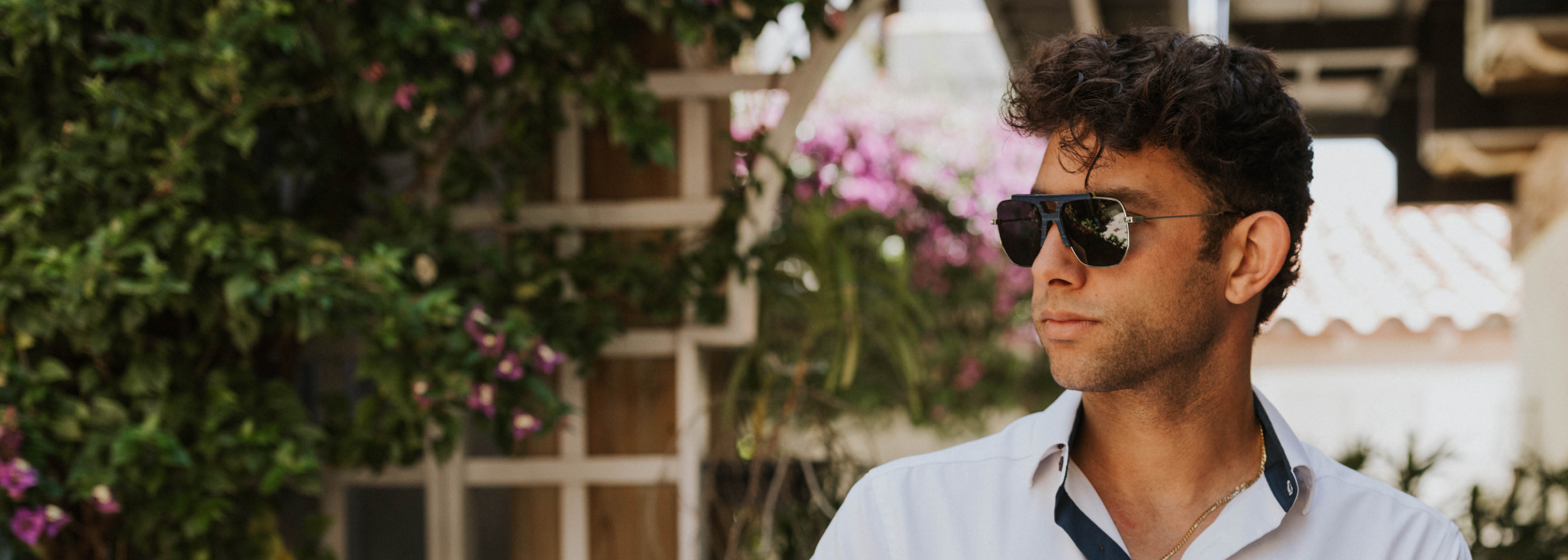 Hudson sunglasses with blue maple and acetate frames worn outdoors in a courtyard on Worth Avenue in Palm Beach