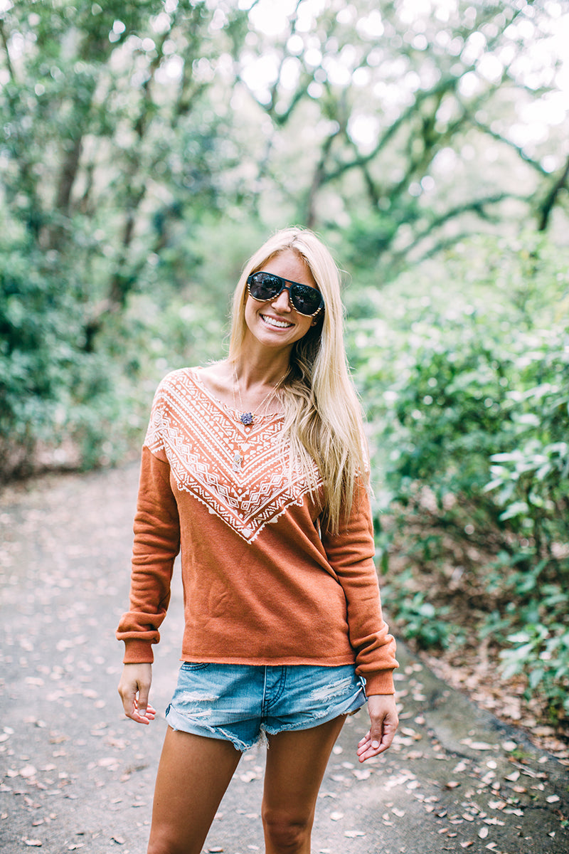 Female in fall colored sweatshirt and jeans shorts wearing our acetate & wood sunglasses in south florida