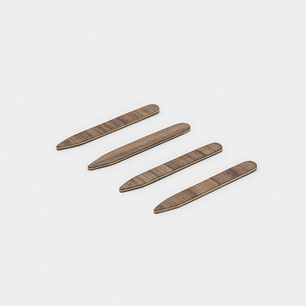 walnut collar stays layed out in a line